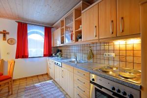 una cocina con armarios de madera y fregadero en Appartement Jöchl en Ellmau