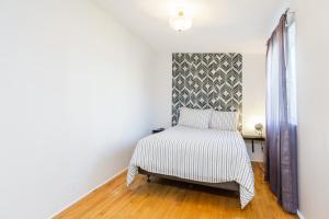 1 dormitorio con 1 cama con manta blanca y negra en Quebec Grand Appartement by Hébergements DCL, en Quebec