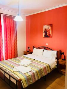 1 dormitorio con 1 cama grande y paredes rojas en Theoxenia Paralio Astros en Parálion Ástros