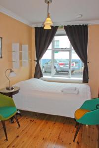 a bedroom with a large white bed and a window at Butterfly Guesthouse in Reykjavík