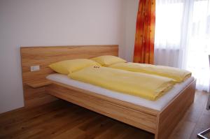 Una cama con sábanas amarillas y almohadas. en Penthaus Appartement, en Sankt Michael im Lungau