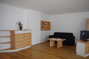 a living room with a black couch and a table at Penthaus Appartement in Sankt Michael im Lungau