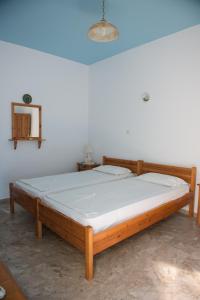 a wooden bed in a room with a white wall at Avra Studios in Myrties