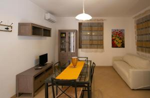 a living room with a table and a couch at Boa Vista San Vito - Area Fitness, Barbecue Area, Tennis Court in San Vito lo Capo