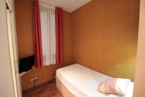 a small bedroom with a bed and a window at Hotel Annex - Rey Don Jaime I in Barcelona