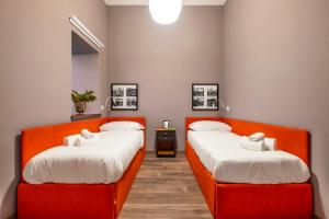 2 letti in una camera con divisori arancioni di Maison Borghese a Sorrento