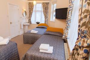 a hotel room with two beds and a sink at Gatwick Turret Guest House in Horley