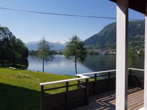 Blick auf einen See von der Veranda eines Hauses in der Unterkunft At The Lakeside II in Skulestadmo