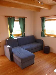 un soggiorno con divano blu e 2 finestre di Ekoraj a Lepa Njiva