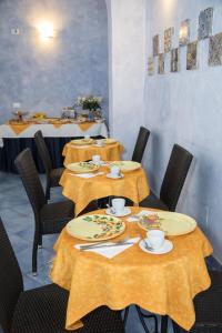 a dining room with tables and chairs with yellow table cloth at Blu Tropea Maison in Tropea