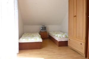 Zimmer mit 2 Betten und einem TV. in der Unterkunft Apartman Foldes Tibor in Veľký Meder