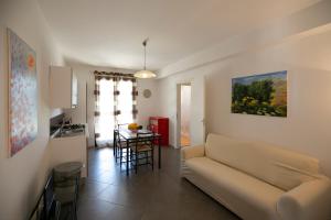 a living room with a couch and a kitchen at Boa Vista San Vito - Area Fitness, Barbecue Area, Tennis Court in San Vito lo Capo
