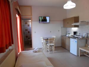 a room with a kitchen and a table with a bed at Ilona Apartments Chania in Kato Daratso