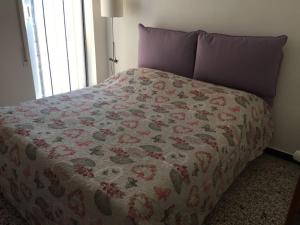 een bed met een dekbed in een slaapkamer bij La cà du cavallu in Noli
