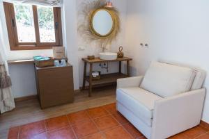 a living room with a chair and a mirror at Hostal La Torre Ibiza Cap Negret in San Antonio