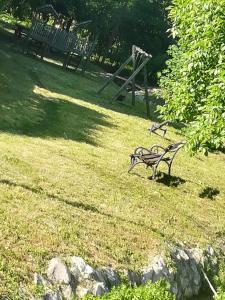 un banc de parc assis dans l'herbe dans un champ dans l'établissement Apartman "Vienna", à Sokobanja