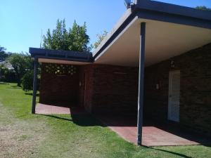 a brick building with a blue overhang on a sidewalk at Brisas Del Rio Apart Hotel in Termas del Daymán