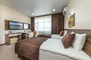 a hotel room with two beds and a desk at Imperial Sun in Anapa