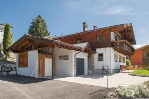 uma grande casa branca com um telhado de madeira em Chalet im Dorf em Goldegg