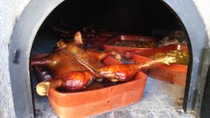 Casas del MonteにあるApartamentos rurales Manoloの鶏肉をオーブンで焼いている