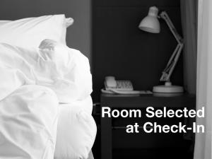 una persona durmiendo en una cama con una lámpara y un teléfono en Holiday Inn Resort Deadwood Mountain Grand, an IHG Hotel, en Deadwood