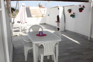 Una mesa blanca y sillas en un patio. en Casa Giorgia, en Noto