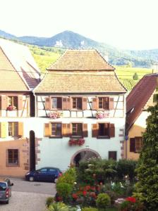 a building with a car parked in front of it at La Maison 1603 in Hunawihr