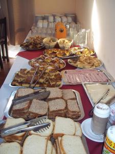 una mesa con diferentes tipos de sándwiches y otros alimentos en Brisas Del Rio Apart Hotel, en Termas del Daymán