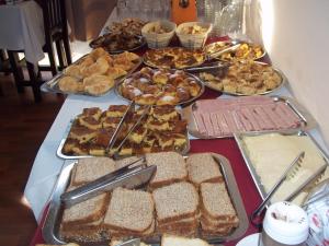 una mesa con muchos tipos diferentes de pan y repostería en Brisas Del Rio Apart Hotel, en Termas del Daymán