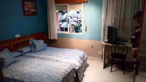 a small bedroom with a bed and a television at Hostal El Venero in Sotillo de la Adrada