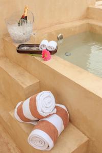 Casona 61 by GuruHotel في ميريدا: حوض استحمام مع منشفة وحوض استحمام