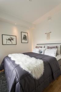 a bedroom with a large bed with a white blanket at Vasko luxurious suites, Nouka in Rovaniemi