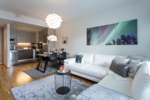a living room with a white couch and a table at Vasko luxurious suites, Nouka in Rovaniemi