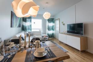 a living room with a couch and a tv at Vasko luxurious suites, Nouka in Rovaniemi
