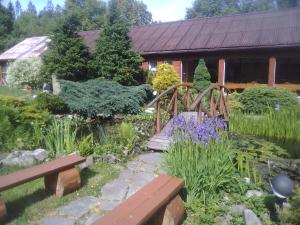 ライツァにあるOśrodek Wczasowy "GRONOSTAJ"の木製の橋と木製のベンチのある庭園