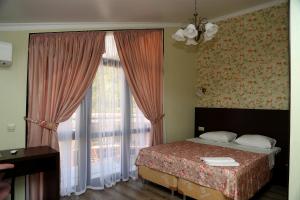 a bedroom with a bed and a large window at Elida in Gagra