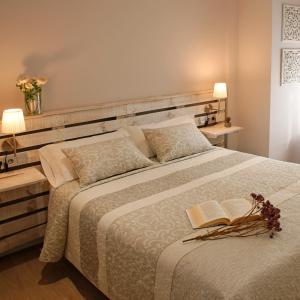アルゲダスにあるApartamento La Noriaのベッドルーム1室(大型ベッド1台、本2冊付)