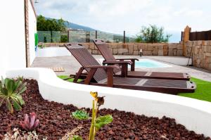 a backyard with two chairs and a pool at MARCELA&JOAQUIN MOUNTAIN HOUSE in Fasnia