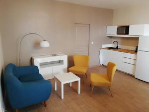 a living room with two chairs and a table and a kitchen at L'Angély - Chambres d'Hôtes in Niort