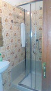 a shower with a glass door in a bathroom at Pensao Avenida in Caldelas