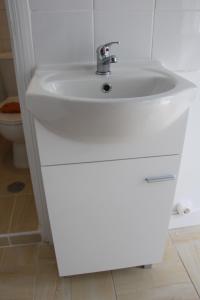 a white sink in a bathroom with a toilet at Lisbon Prime Hostel & Rooms in Lisbon