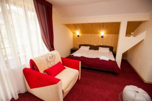 um quarto de hotel com uma cama e duas cadeiras em Zdybanka em Bukovel