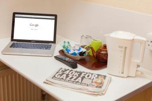 un ordenador portátil sobre una mesa blanca en Gatwick Turret Guest House, en Horley