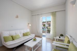 a white living room with a couch and a table at The Orange Garden in Kassiopi