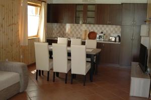 cocina con mesa de comedor y sillas blancas en Faház, en Tiszaszőlős 24 fotos más