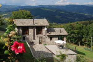 a stone house with a view of the mountains at Il Paradiso monolocale Cottage in Albareto