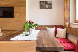 ヴェルトゥルノにあるBachmannhofのワイン1本と花のテーブル
