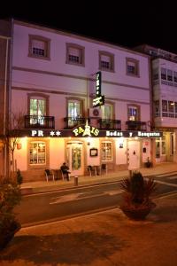 un edificio con un cartel en él por la noche en Hostal-Restaurante Paris, en Forcarei