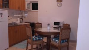 a kitchen with a table with chairs and a microwave at House Paradise in Širitovci