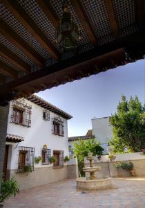 einen Innenhof mit einem Brunnen vor einem Gebäude in der Unterkunft Aljibe del Albayzin in Granada
